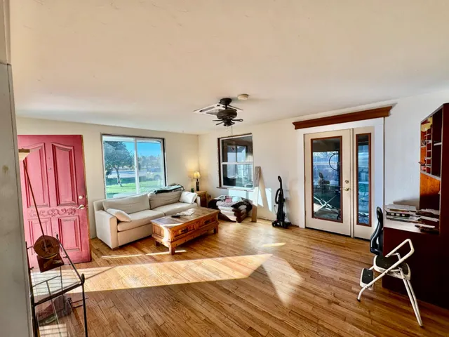 a kitchen with stainless steel appliances granite countertop a stove top oven a sink and a dining table with wooden floor