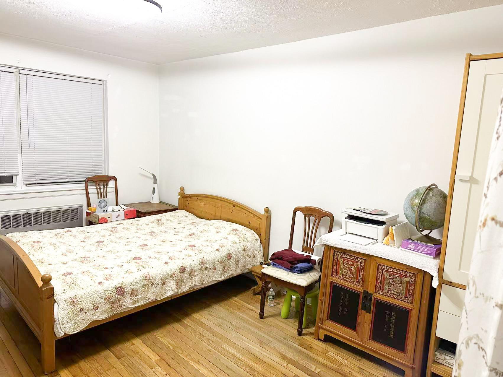 138-32 68th Drive, Unit 2B Queens, NY 11367 - Photo 7 of 10 a bedroom with a bed wooden floor and lamp