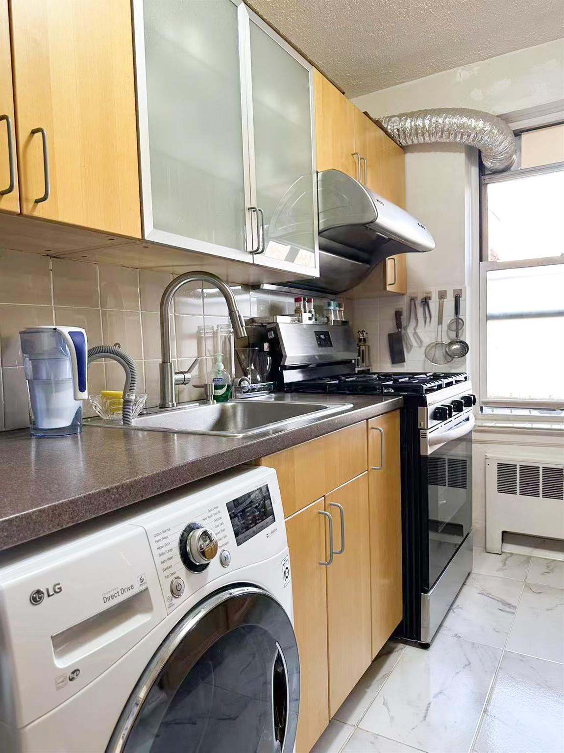 138-32 68th Drive, Unit 2B Queens, NY 11367 - Photo 8 of 10 a kitchen with stainless steel appliances granite countertop a sink and a stove