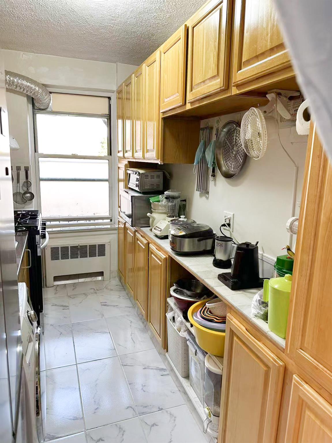 138-32 68th Drive, Unit 2B Queens, NY 11367 - Photo 9 of 10 a kitchen with stainless steel appliances granite countertop a stove and a sink