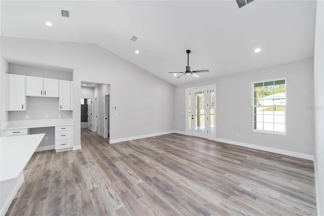 a view of empty room with wooden floor and window