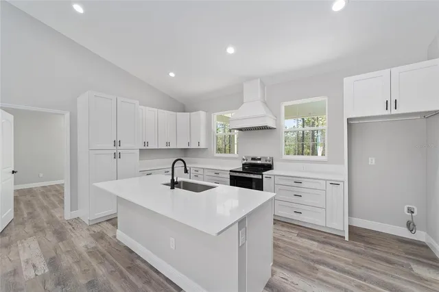 a kitchen with granite countertop a sink a counter space appliances and cabinets