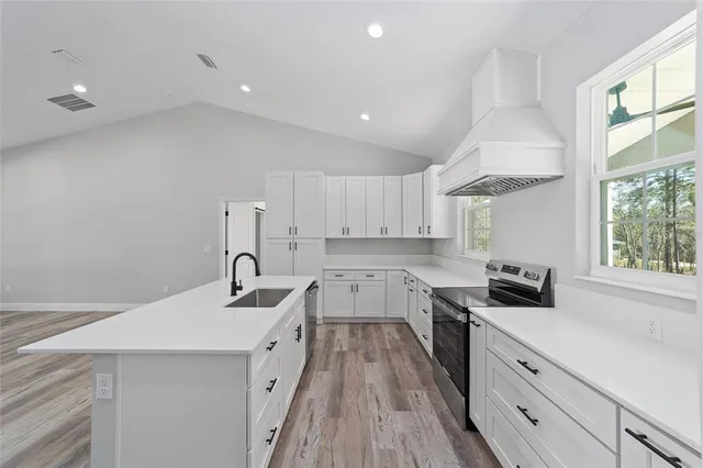 a kitchen with a sink a stove and cabinets