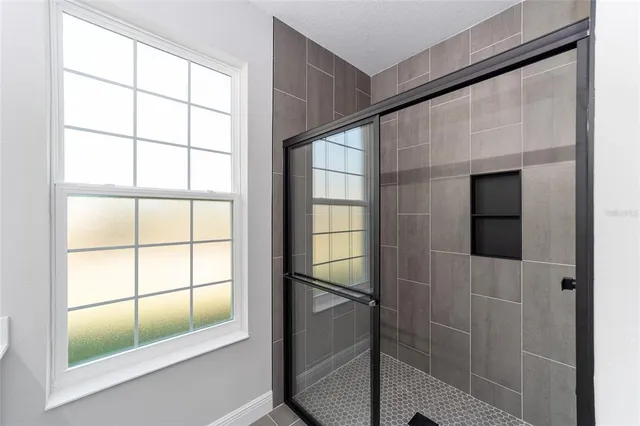a bathroom with a window and a shower