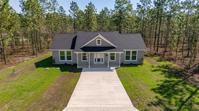 a aerial view of a house with a yard basket ball court and outdoor seating