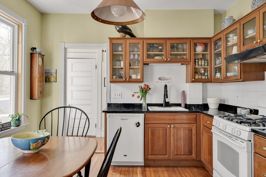 32 Locke Street Cambridge, MA 02140 - Photo 16 of 32 a kitchen with stainless steel appliances granite countertop a dining table chairs cabinets a stove and a window