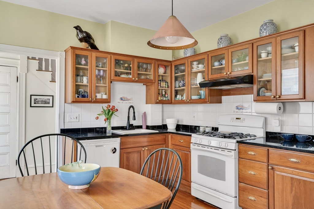 32 Locke Street Cambridge, MA 02140 - Photo 17 of 32 a kitchen with stainless steel appliances granite countertop a sink a stove cabinets dining table and chairs