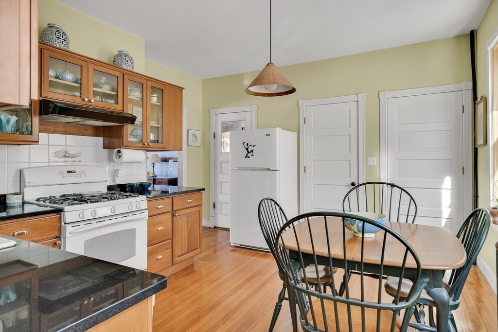 32 Locke Street Cambridge, MA 02140 - Photo 18 of 32 a kitchen with stainless steel appliances granite countertop a stove a refrigerator a oven a dining table and chairs with wooden floor