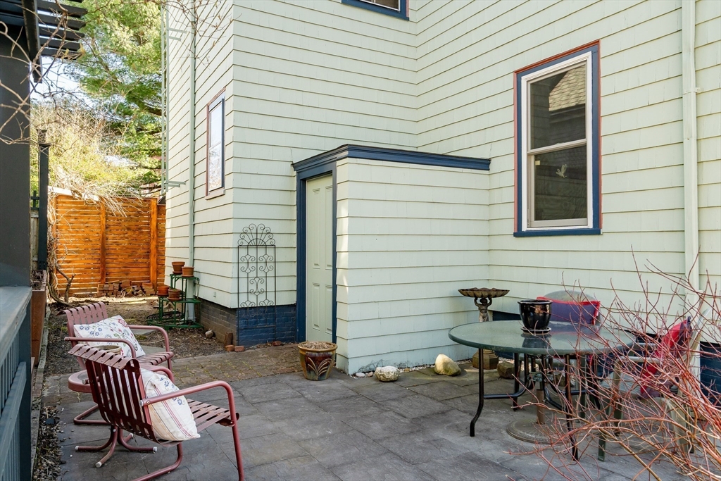 32 Locke Street Cambridge, MA 02140 - Photo 27 of 32 a view of a patio with a table and chairs and a barbeque