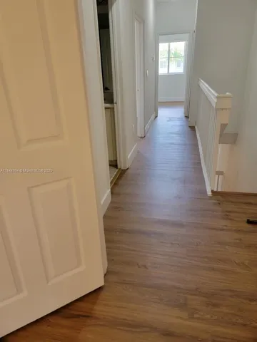 an empty room with wooden floor and closet