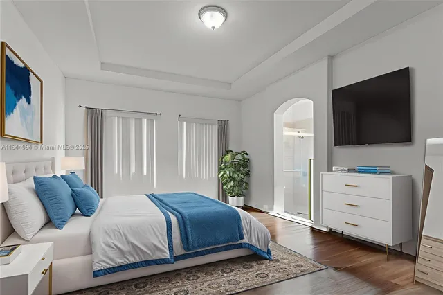 a bedroom with a bed and flat screen tv