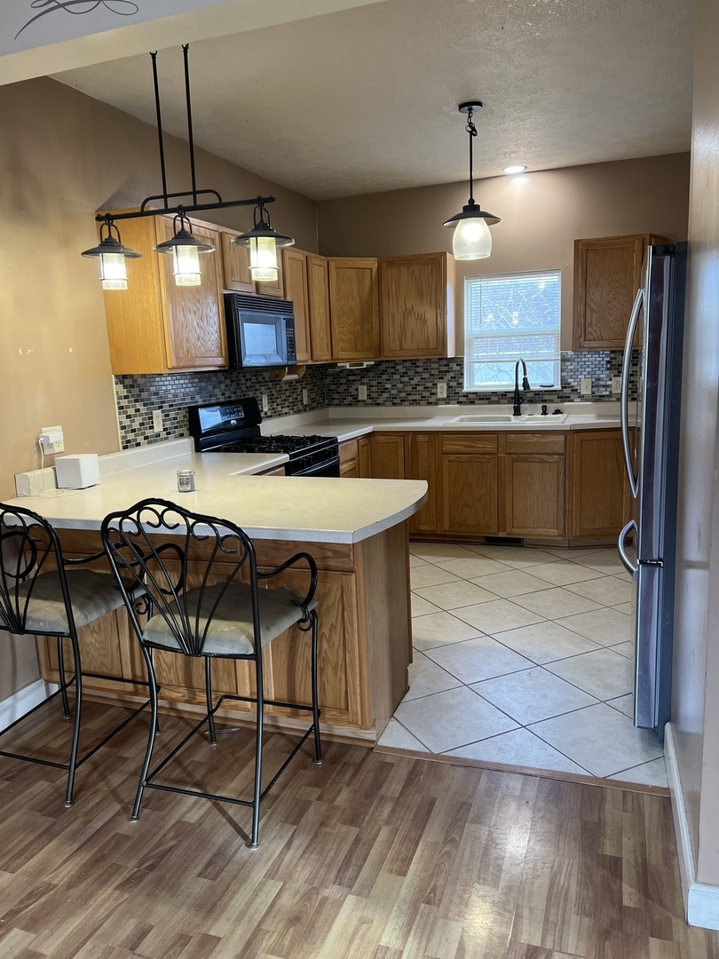 304 South 3rd Street Kirkland, IL 60146 - Photo 6 of 16 a kitchen with stainless steel appliances granite countertop a kitchen island a stove a table and chairs
