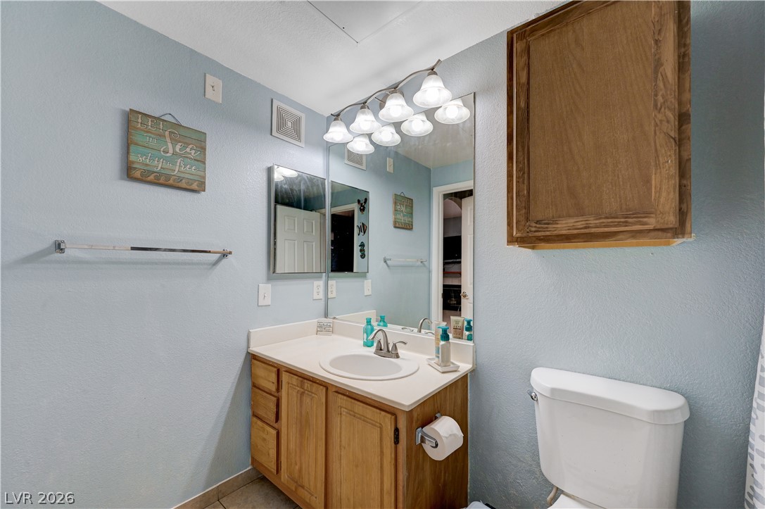 8555 West Russell Road, Unit 1017 Las Vegas, NV 89113 - Photo 16 of 34 A compact full bathroom featuring a light wood vanity with a single sink and overhead lighting.