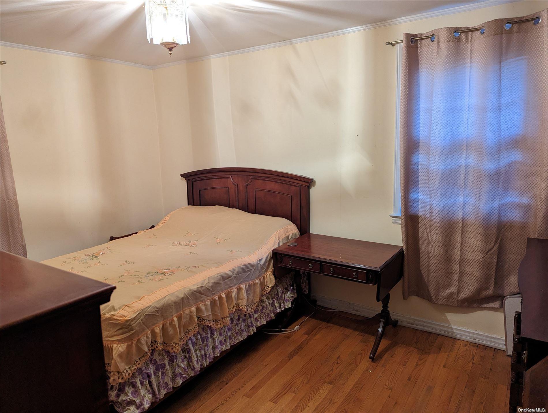Undisclosed Address Queens, NY 11365 - Photo 12 of 18 a bedroom with a bed and a table in it