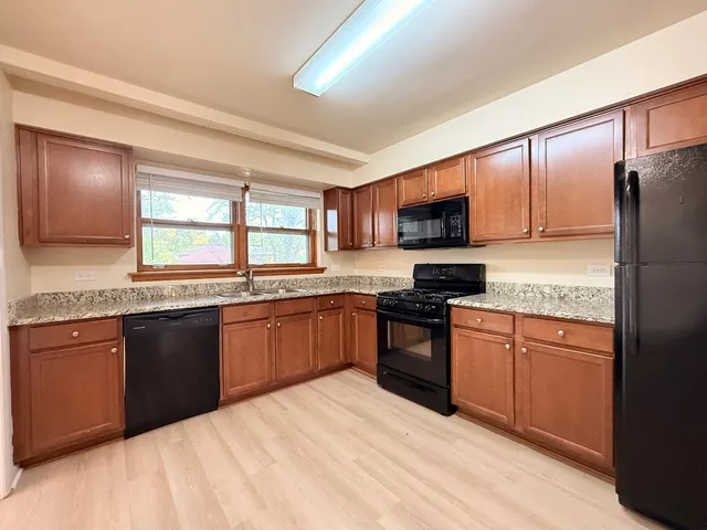 a kitchen with granite countertop stainless steel appliances and wooden cabinets