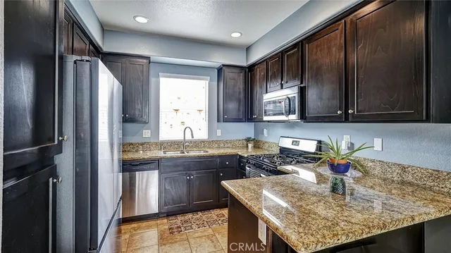 a kitchen with stainless steel appliances granite countertop wooden cabinets a sink and dishwasher