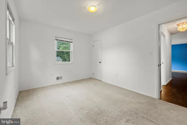 an empty room with closet and windows