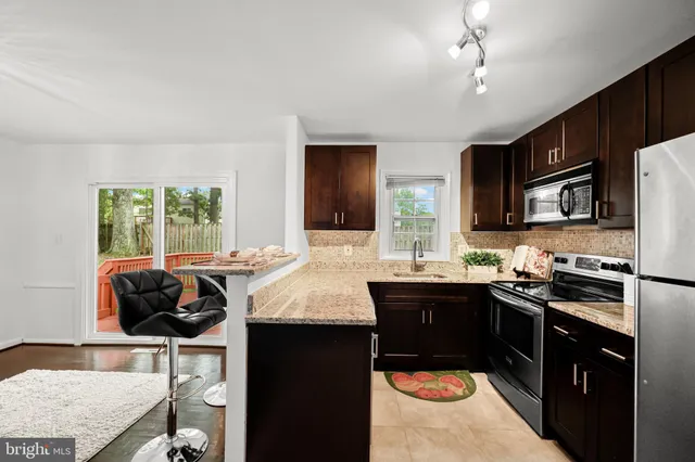 a kitchen with granite countertop a sink cabinets and window