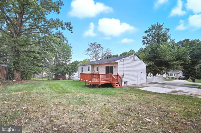 a view of backyard with wooden fence and a large tree