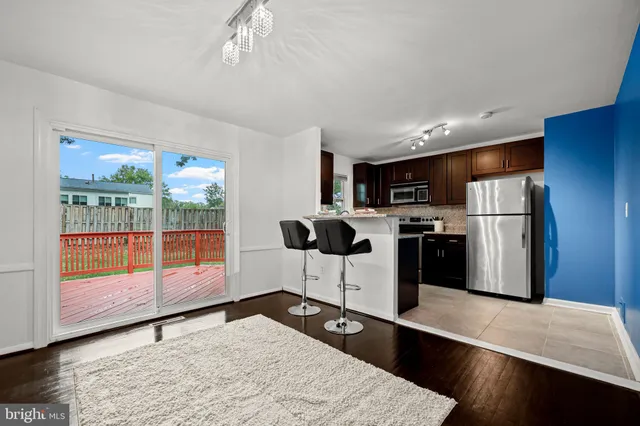 a kitchen with stainless steel appliances kitchen island granite countertop a refrigerator and a stove top oven