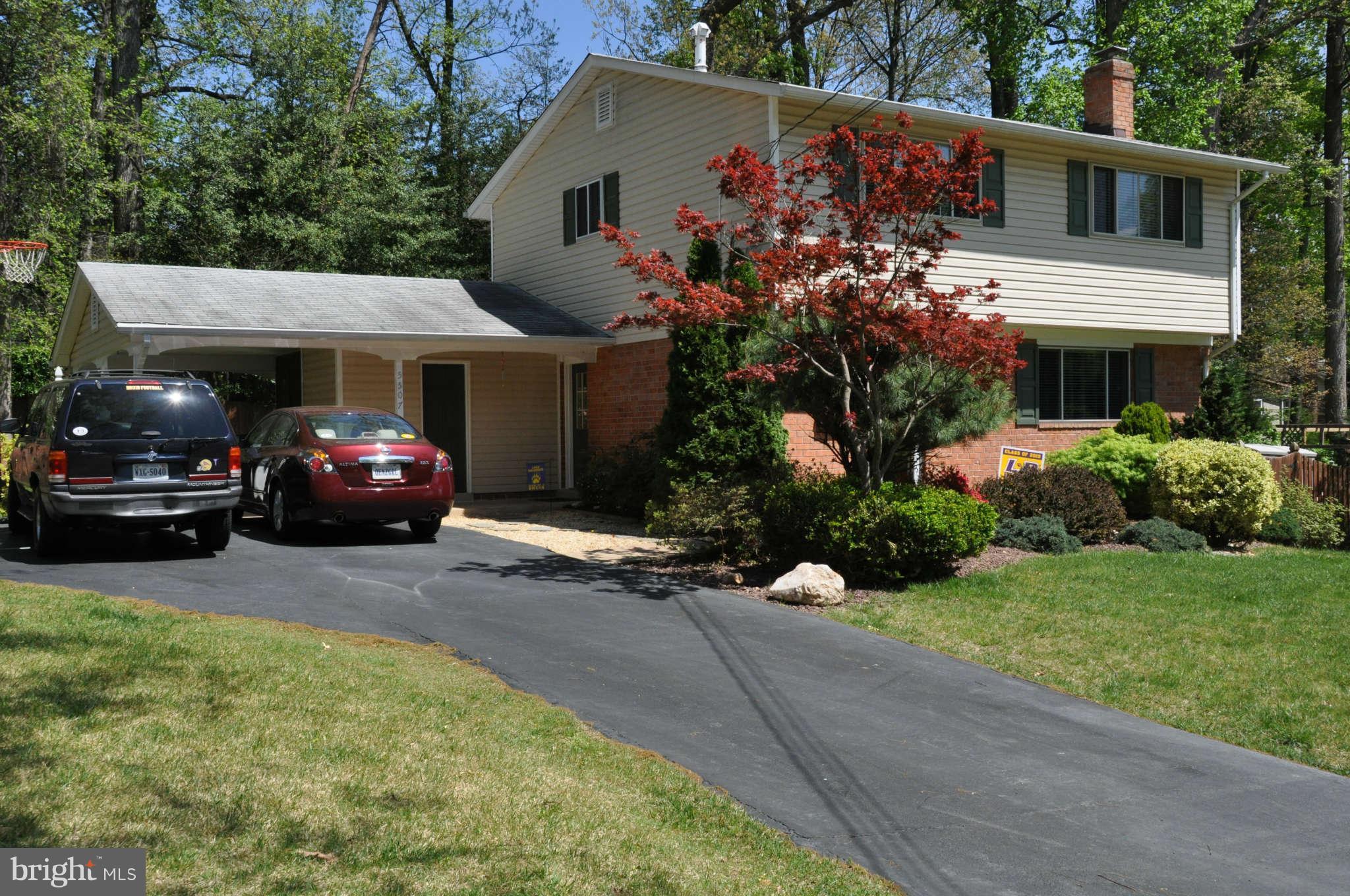a front view of a house with cars parked on road