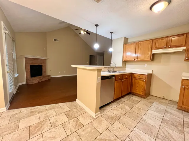 a kitchen with a stove a sink dishwasher and a refrigerator