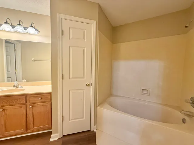 a bathroom with a tub a sink and a large mirror