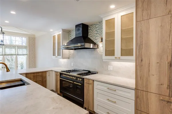 a kitchen with stainless steel appliances granite countertop a sink a stove and a refrigerator