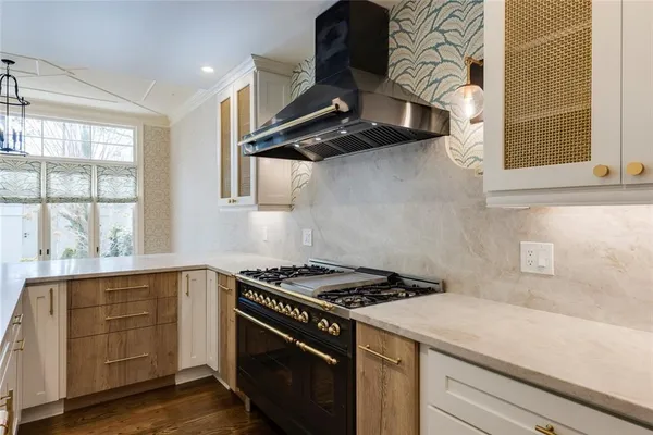 a kitchen with a stove and a white wooden cabinets