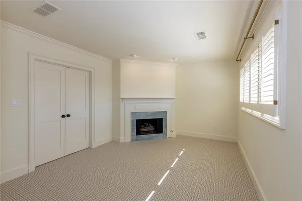 a view of an empty room with a window and fireplace
