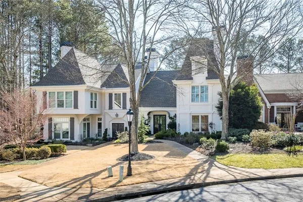 a view of a white house with a yard chairs and fire pit