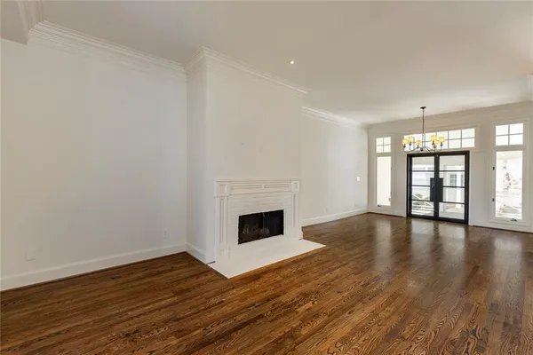 wooden floor fireplace and windows in an empty room