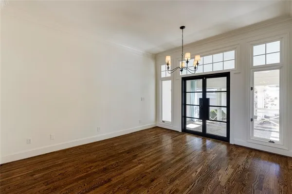 a view of an empty room with window and wooden floor