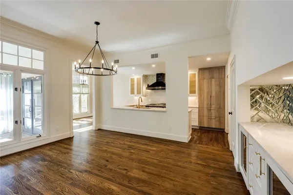 a view of a kitchen center island wooden floor and stainless steel appliances