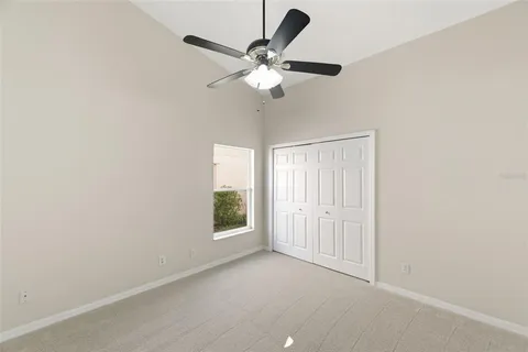 an empty room with a window and a fan