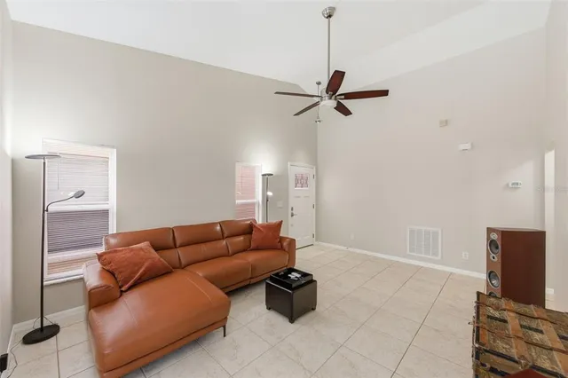 a living room with furniture a ceiling fan and a rug