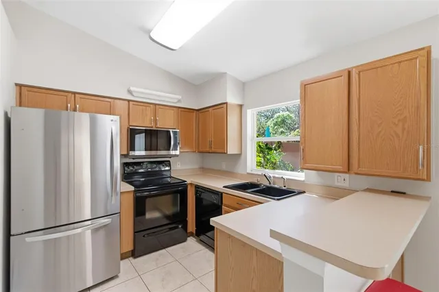 a kitchen that has a refrigerator a sink and a stove in it