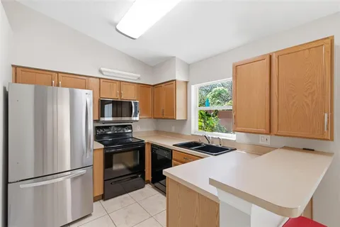 a kitchen that has a refrigerator a sink and a stove in it