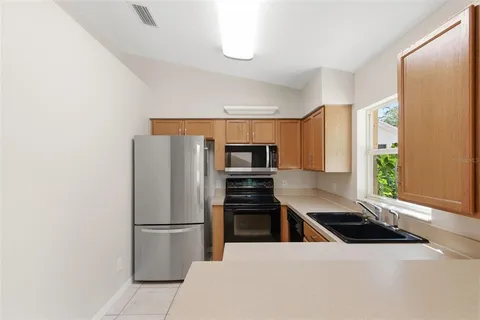 a kitchen with stainless steel appliances a refrigerator a stove a sink a counter space and cabinets