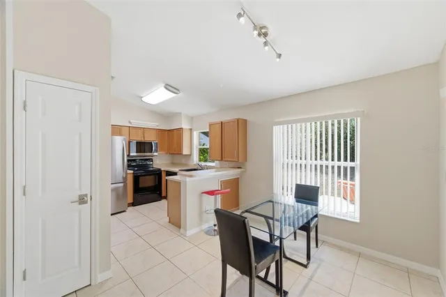 a kitchen with a refrigerator and chairs
