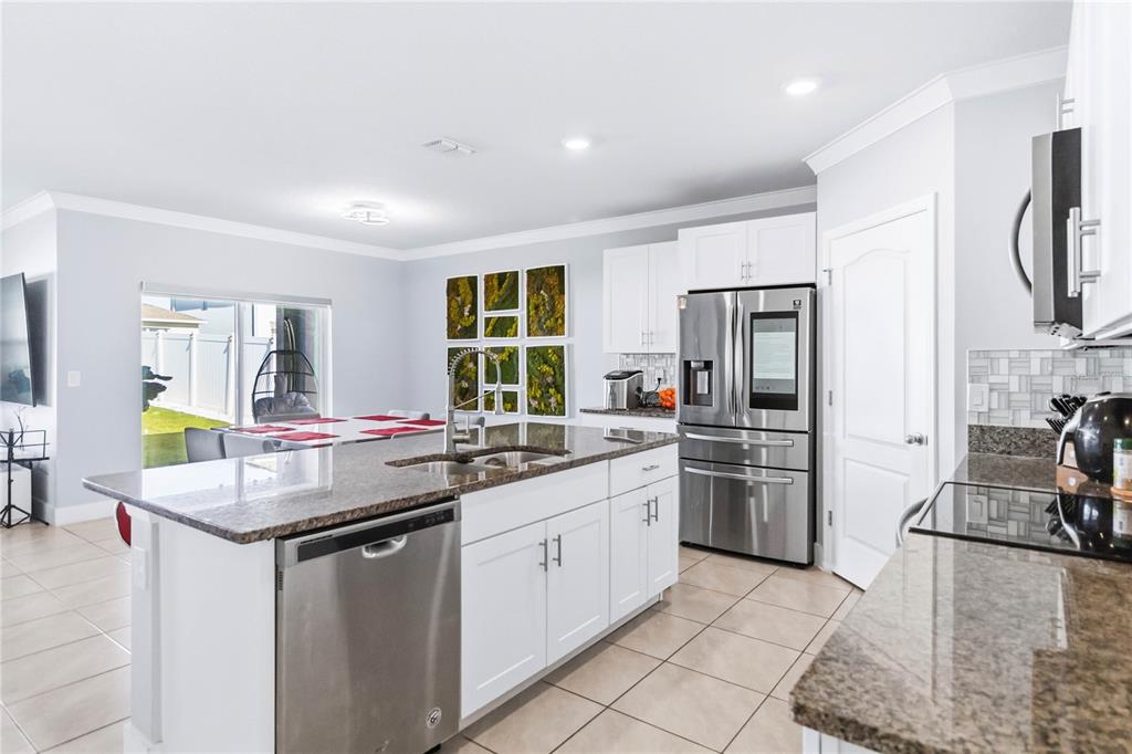 1759 Copinger Terrace Kissimmee, FL 34744 - Photo 11 of 29 a kitchen with stainless steel appliances granite countertop a sink stove and refrigerator