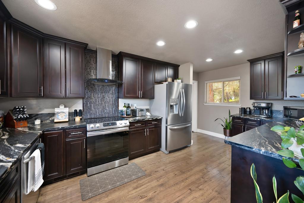 2378 Cascade Trail Cool, CA 95614 - Photo 14 of 57 a kitchen with stainless steel appliances granite countertop sink stove refrigerator and cabinets