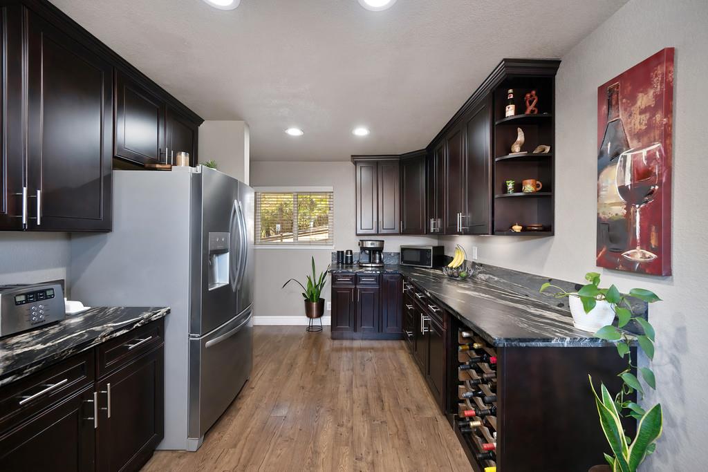 2378 Cascade Trail Cool, CA 95614 - Photo 16 of 57 a kitchen with stainless steel appliances granite countertop a refrigerator a stove and a wooden floors