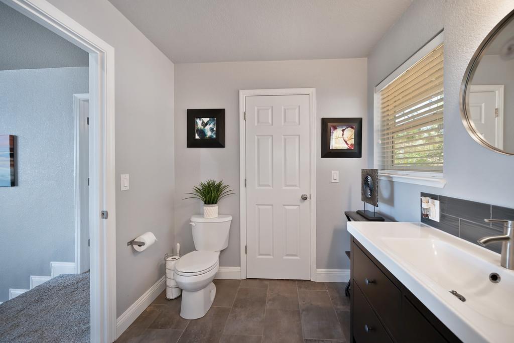 2378 Cascade Trail Cool, CA 95614 - Photo 28 of 57 a bathroom with a toilet a sink and a large mirror