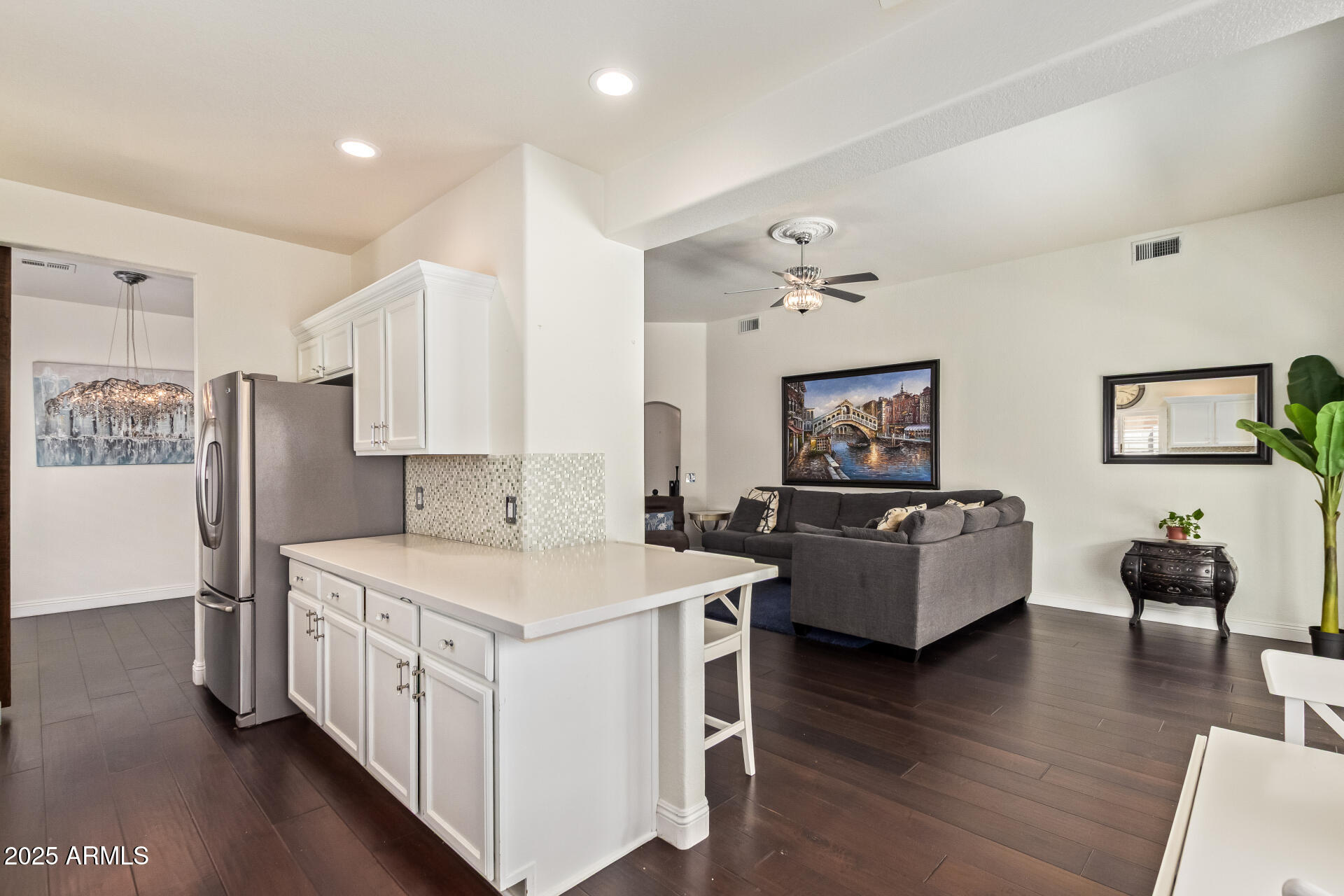 19606 North 23rd Way Phoenix, AZ 85024 - Photo 20 of 41 a kitchen with stainless steel appliances a white stove top oven a sink a living room and couches with wooden floor