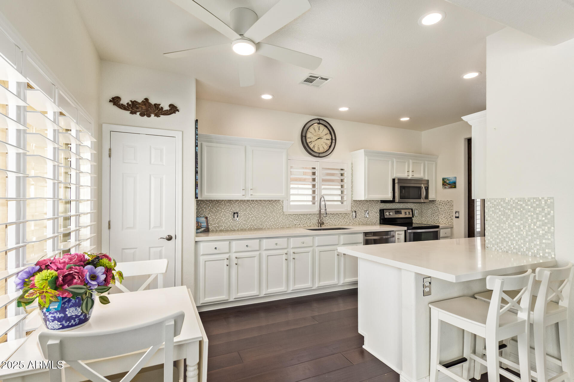 19606 North 23rd Way Phoenix, AZ 85024 - Photo 3 of 41 a kitchen with stainless steel appliances a stove a sink dishwasher and white cabinets with wooden floor