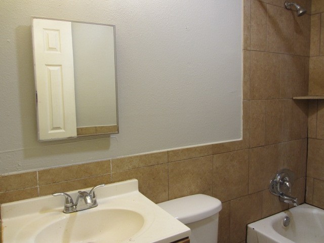 505 13th Street Huntsville, TX 77340 - Photo 10 of 12 a bathroom with a sink a toilet and mirror