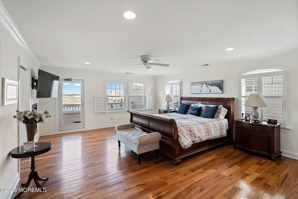 a spacious bedroom with a bed and wooden floor