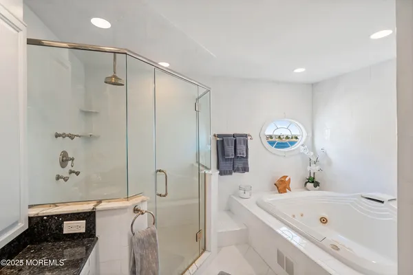 a bathroom with a tub a sink and a shower