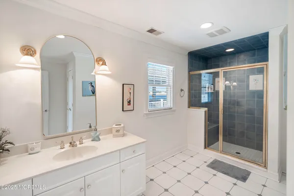 a spacious bathroom with a shower sink and mirror
